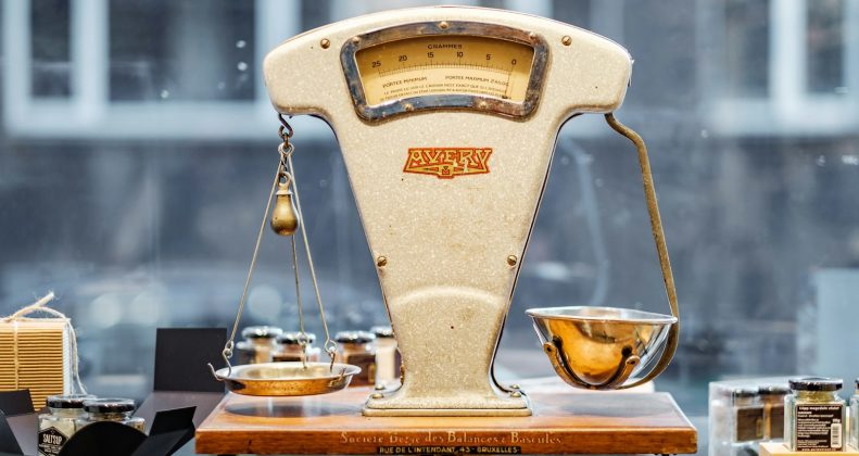 Brass balance scale weighing two sides