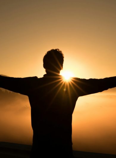 Silhouette of a person on a cliff at sunset
